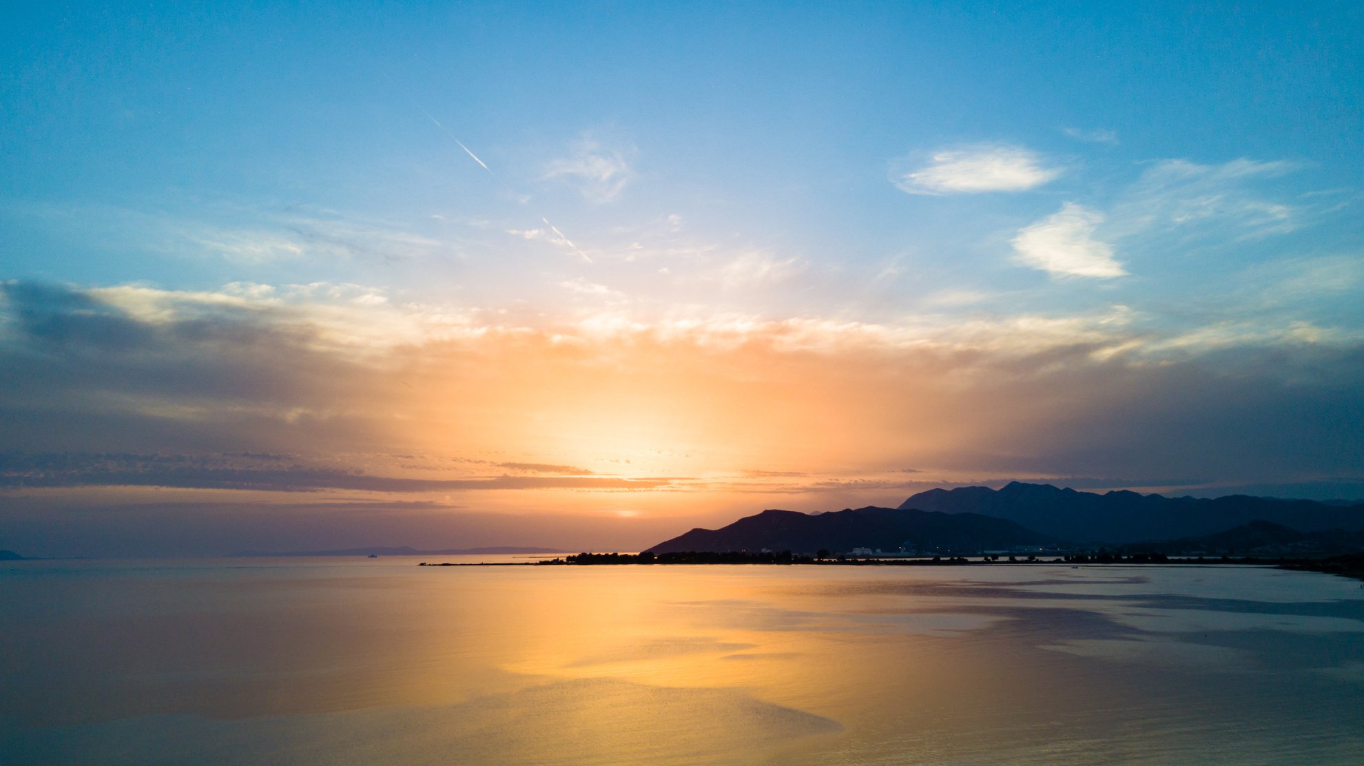 Inspirational beautiful sunset landscape at sea and mountains